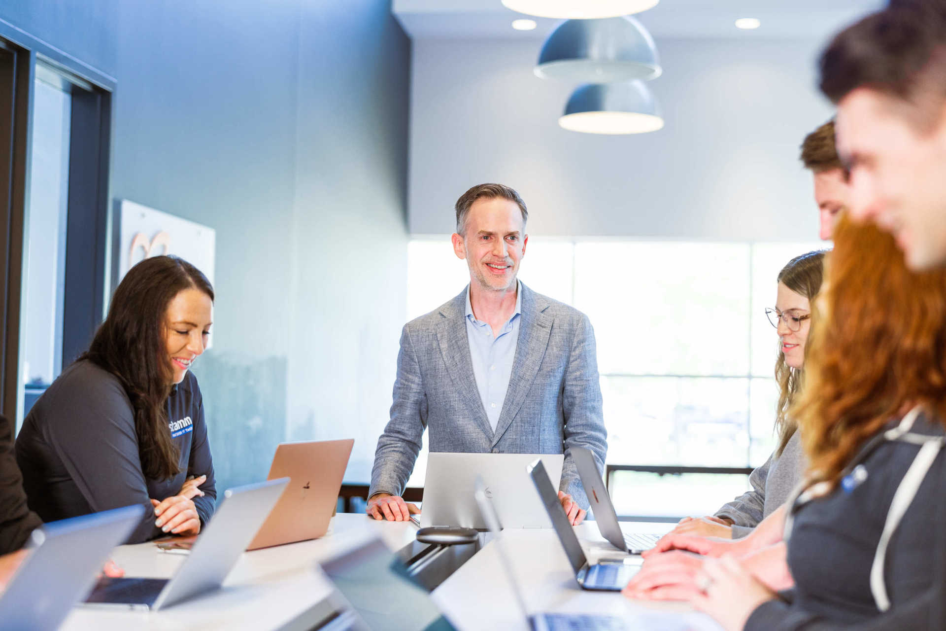 Stamm employees gathering around a table for a standup meeting
