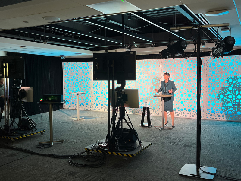 a woman standing on a production set with monitors and lighting 