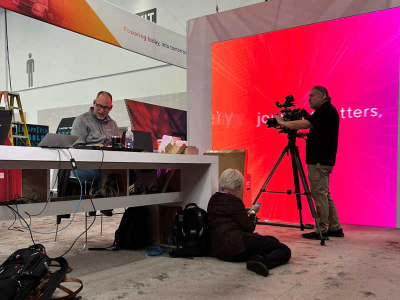 a camera crew filming someone at a desk