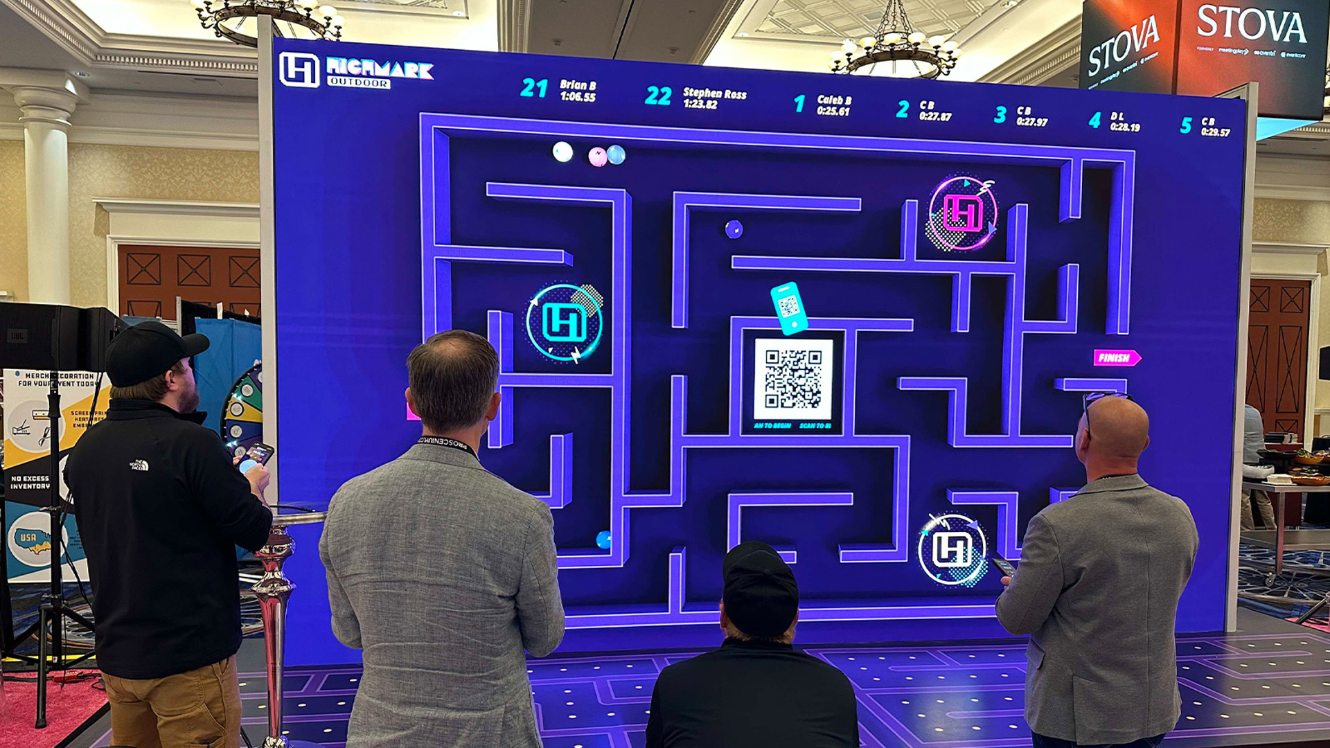 People standing in front of a Highmark LED wall that's displaying a game 