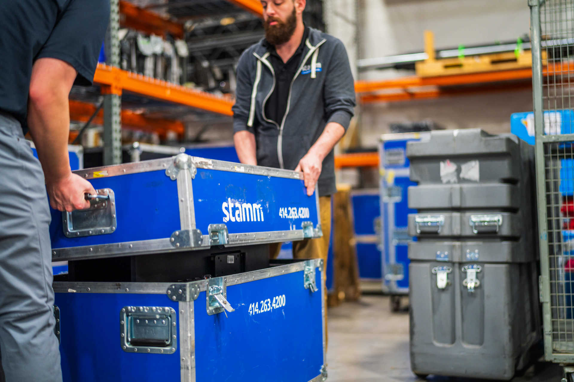 Two Stamm employees working together to close an IT traveling case in the warehouse